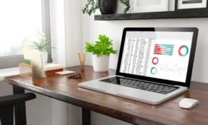 A Google Sheets dashboard that is on a laptop sitting on top of a tidy desk. Showing a nice a spreadsheet dashboard can look.